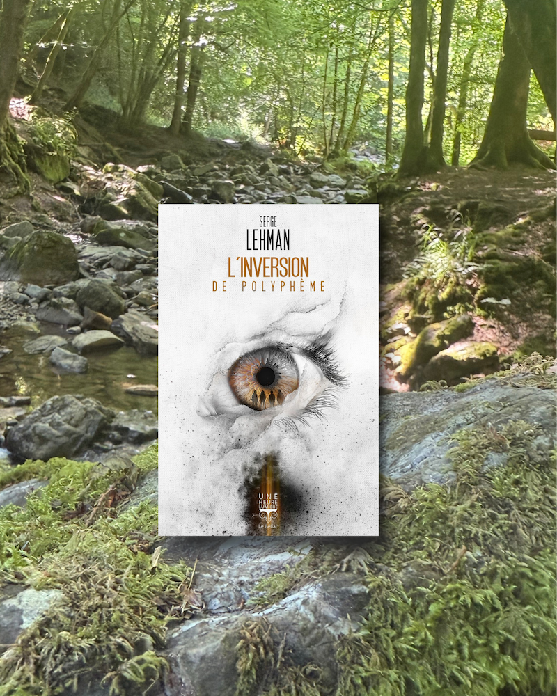 Livre posé sur un rocher en forêt. La couverture de L’inversion de Polyphème montre un oeil dans lequel on voir 4 silhouettes 